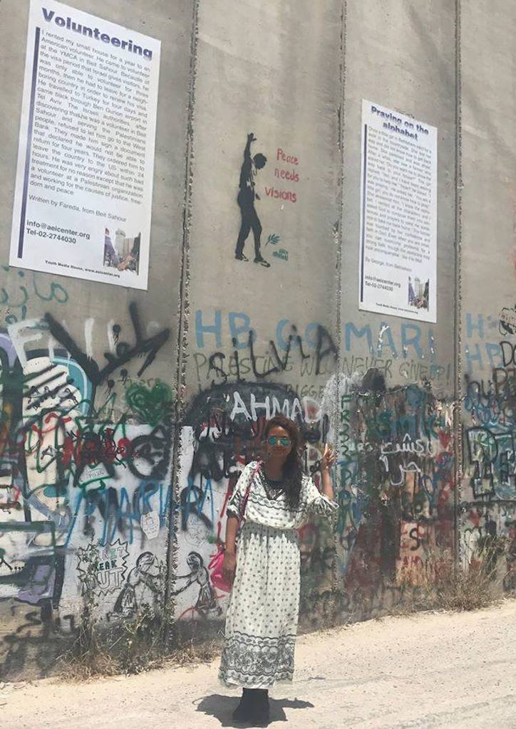 Regine Guevara at the Wall of Banksy during her time in Palestine