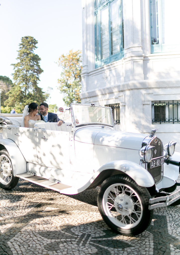 The couple share a tender moment in their wedding car (Photograph by Catarina Zimbarra)
