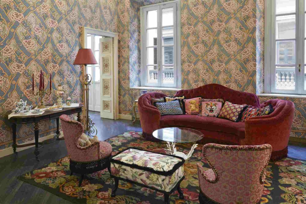 deep red antique sofa and floral patterned walls